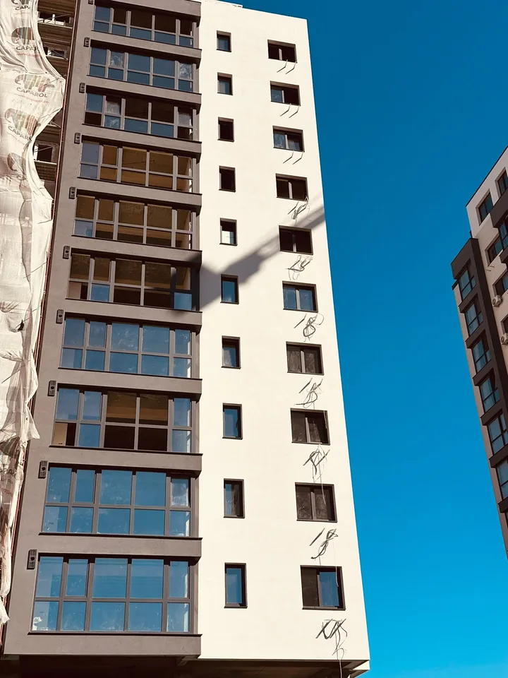 Fațadă de bloc finalizată cu termosistem și tencuială decorativă albă, Tătărași, Iași