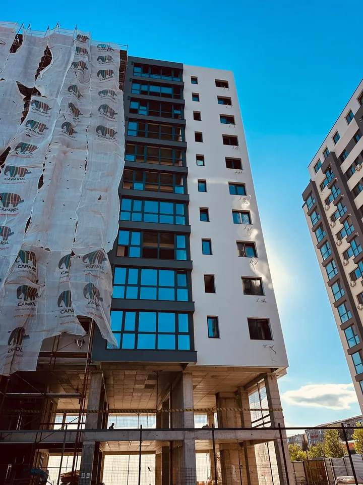 Bloc cu schelă și plasă de protecție, fațadă parțial finalizată, Tătărași, Iași